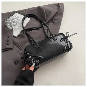 Detail of black glossy patent leather bowling bag with punk metal eyelet drawstrings