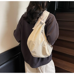 Detail of cream canvas dumpling bag showing large capacity and soft texture