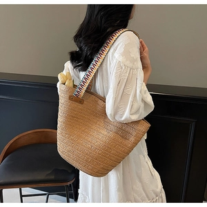 Detail view of woven straw tote bag with colorful ethnic strap and large capacity
