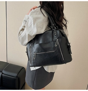 Vista macro della grande borsa tote nera con borchie argento vintage e zip dettagli