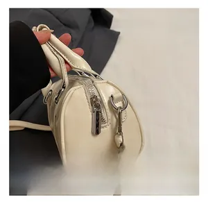 Close-up of premium silver hardware and zipper on creamy white pillow handbag