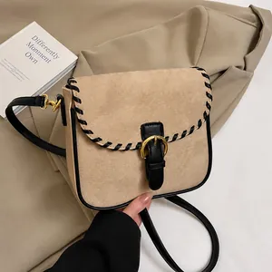 Detail der khakifarbenen Mattledertasche mit schwarzer Flechtkante und goldener Schnalle