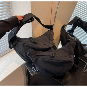 Detailed comparison of two sizes of black nylon crescent bags with adjustable straps