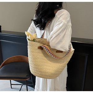 Detail of woven straw tote bag with multi-color geometric strap and tulip decorations