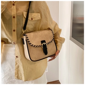 Beige Wildleder Umhängetasche mit schwarzer Webkante und goldener Ringschnalle am Modell