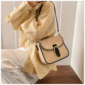 Vintage-Umhängetasche in Beige mit schwarzen Flechtkanten und goldener Schnalle am Model