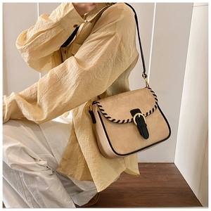 Detail der beige Umhängetasche mit schwarzen Steppnähten und goldener Schnalle