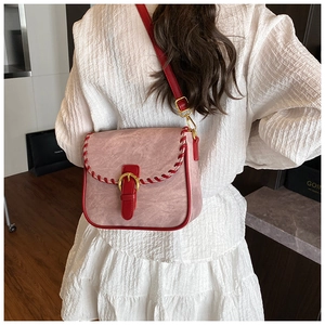 Detail der Satteltasche aus rosa Wildleder mit rotem Lederriemen und Ziernähten