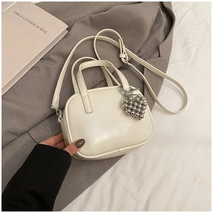 Détail du sac à main en cuir PU crème avec poignée courte et breloque coeur argenté