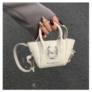 Dettaglio mini borsa a tracolla bianco crema con texture grana litchi e anelli d'argento