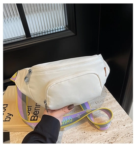 Detail of ivory sports waist bag with wide colorful patterned strap and dual zippers