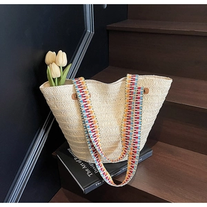 Detail of woven straw tote bag with colorful jacquard straps and tulip decor