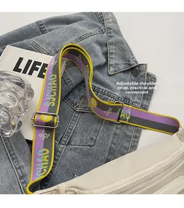 Close-up of white nylon chest bag featuring adjustable colorful wide strap with embroidery