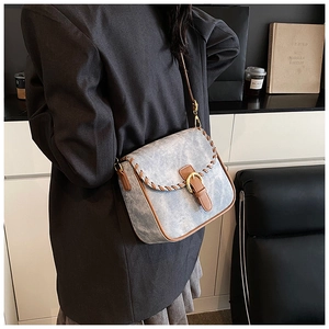 Detailaufnahme der Vintage-Umhängetasche aus Denim mit braunem Lederbesatz und Schnalle