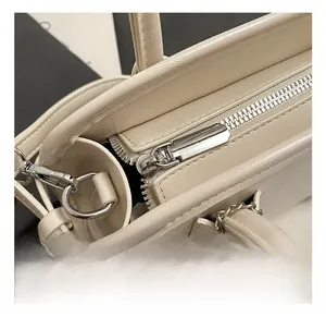Détail macro de la fermeture éclair argentée sur un sac Boston beige vintage