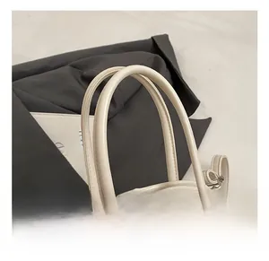 Détails des poignées de cabas en cuir crème avec finitions de couture précises