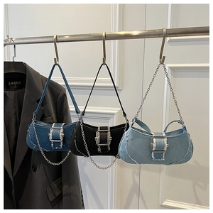Detailed view of three vintage denim underarm bags with metal chains and frayed edges