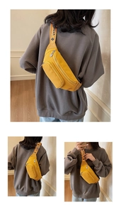 Detail of bright yellow nylon chest bag with CHAO embroidered strap and zipper compartments
