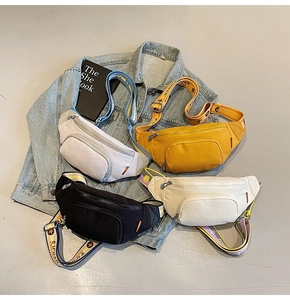 Flat lay of colorful canvas chest bags with decorative patterned straps on denim jacket