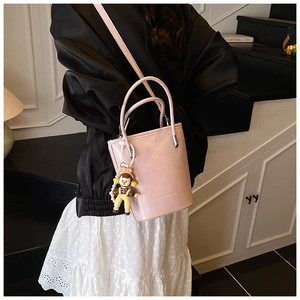 Roze emmertas met lange riem en poppenhanger op een moderne trap getoond