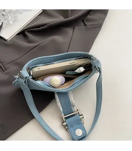 Interior view of denim shoulder bag showing spacious storage for phone and cosmetics