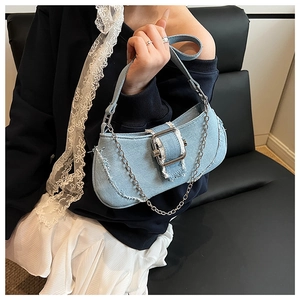 Detail of light blue denim shoulder bag with silver chain and frayed edge design
