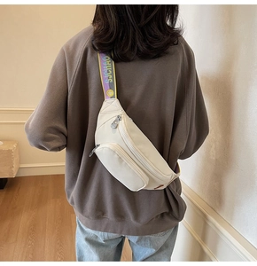 Detail of white nylon chest bag featuring a wide jacquard strap with SJCHAO lettering