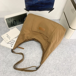 Makro-Detail der khakifarbenen Nylon-Halbmondtasche mit Leder-Logo und Reißverschluss