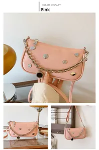Pink crescent underarm bag with silver chain and heart rivets in Y2K punk style