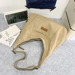 Detail der beige Halbmond-Canvas-Tasche mit verstellbarem Riemen und Leder-Patch