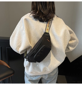 Detail of nylon crossbody chest bag featuring wide colorful strap with Sichuan lettering