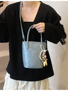 Chique blauwgrijze emmertas voor dames met een poppenhanger en parelketting detail