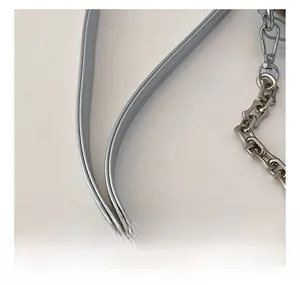 Detail of the light blue leather shoulder strap with silver chain and metal lobster clasp