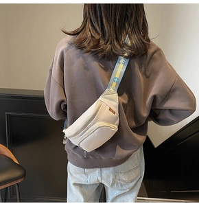 Detail of light beige chest bag with jacquard embroidered strap on model's back