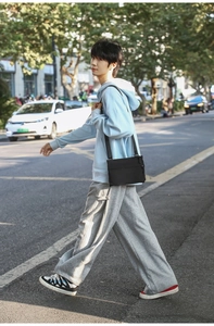 Outdoor lifestyle shot of a lightweight black nylon crossbody bag for daily street style