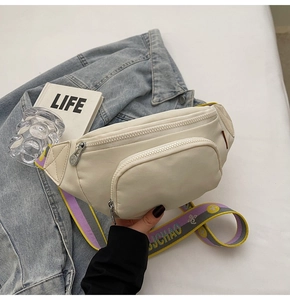 Detail of cream nylon chest bag with colorful woven strap and metallic zipper closure