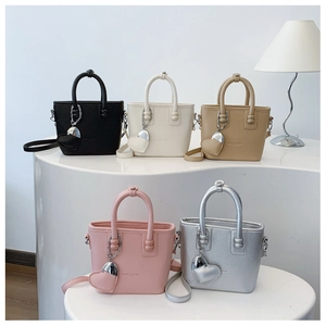 Detailansicht bunter Eimer-Handtaschen mit Herzanhängern und eleganten Metallketten