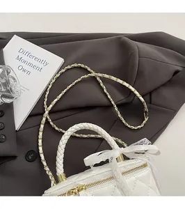 Close-up of quilted white leather box bag with lace bow detail and chain strap