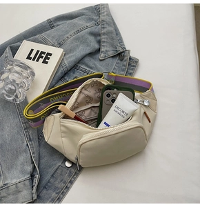 Detail of beige crossbody bag with wavy strap showing spacious interior for essentials