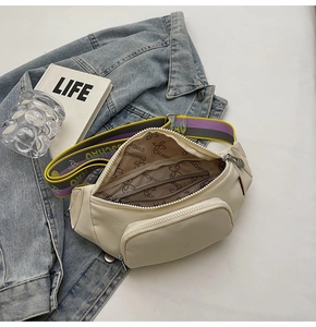 Detail of cream nylon chest bag with colorful wide shoulder strap and front zipper pocket