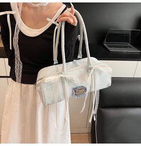 Detail der hellblauen Denim-Boston-Tasche mit weißen Schleifen und Spitzenakzenten