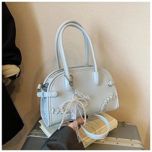 Détail du sac Boston bleu clair avec motifs tissés et pendentif noeud en dentelle perlée