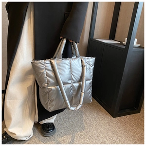 Détail du sac fourre-tout argenté matelassé avec texture rembourrée et fini métallisé chic