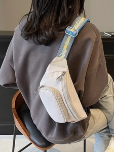 Beige crossbody chest bag with colorful jacquard strap shown from a back-view perspective