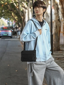 Minimalist black nylon crossbody bag for men with adjustable strap and front zipper pocket