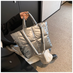 Vue détaillée d'un grand sac cabas argenté matelassé en nylon métallique avec bandoulière