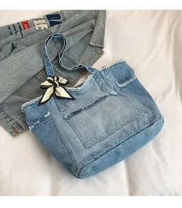 Gros plan du sac cabas en jean avec bords effilochés et foulard en soie décoratif sur l'anse