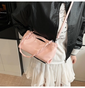Detail of light pink glossy PU leather drawstring bag with pleated cloud design texture