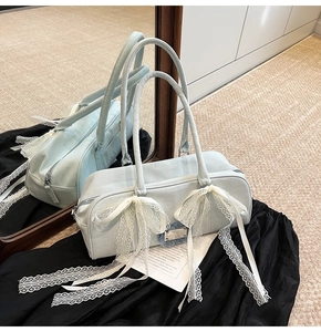 Detailansicht der hellblauen Denim-Boston-Tasche mit großen weißen Spitzen-Schleifen