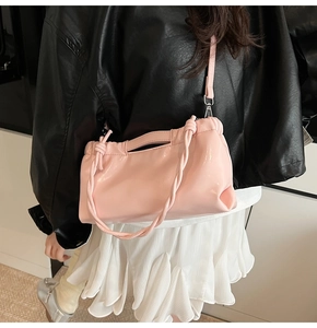 Detail of light pink PU cloud bag with decorative woven knot handle and thin strap